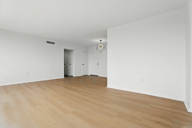 700 E 9th J St, Little Rock, AR 72202 - unfurnished room featuring light wood finished floors, a chandelier, and baseboards