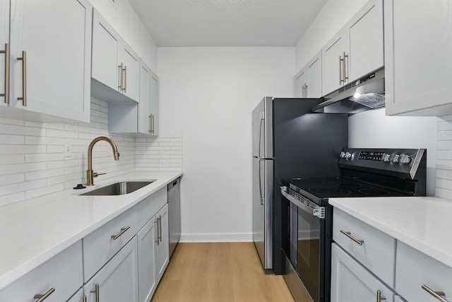 700 E 9th J St, Little Rock, AR 72202 - kitchen with electric range, under cabinet range hood, a sink, light wood finished floors, and tasteful backsplash
