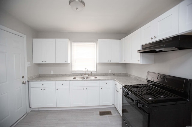 3316 Zion St, Little Rock, AR 72204 - kitchen featuring black gas stove, under cabinet range hood, a sink, white cabinetry, and light countertops
