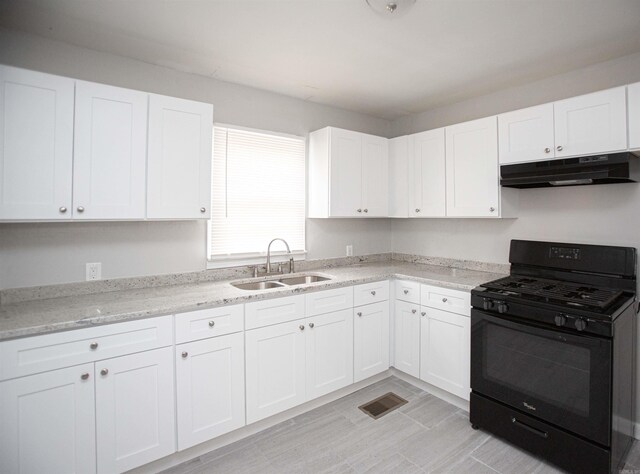 3316 Zion St, Little Rock, AR 72204 - kitchen with black gas range oven, under cabinet range hood, a sink, white cabinets, and light stone countertops