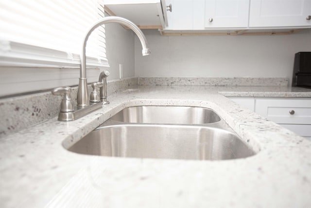 3316 Zion St, Little Rock, AR 72204 - kitchen view of a sink, white cabinetry, and light stone counters