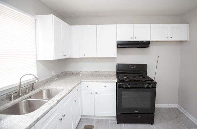 3316 Zion St, Little Rock, AR 72204 - kitchen with gas stove, under cabinet range hood, a sink, white cabinets, and light stone countertops