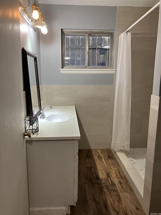 5006 Manor Ave, Little Rock, AR 72204 - full bathroom featuring vanity, wood finished floors, tiled shower, and tile walls