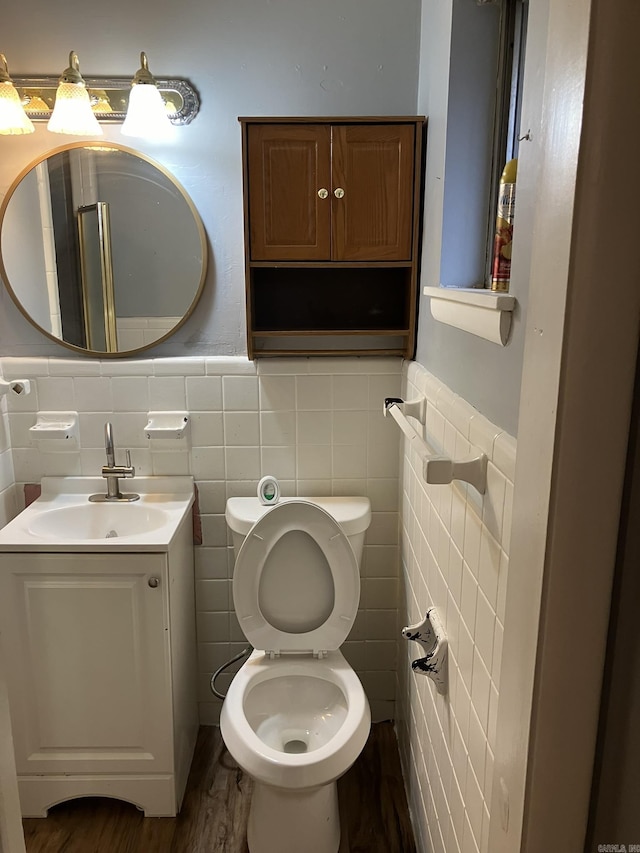 5006 Manor Ave, Little Rock, AR 72204 - half bath with tile walls, wood finished floors, vanity, toilet, and wainscoting