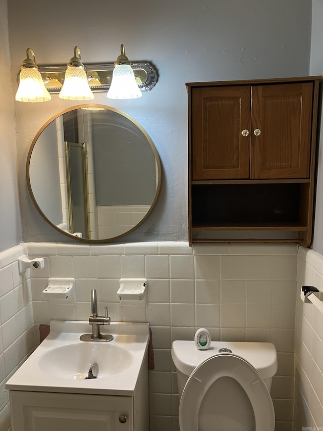 5006 Manor Ave, Little Rock, AR 72204 - bathroom with toilet, tile walls, vanity, and a wainscoted wall