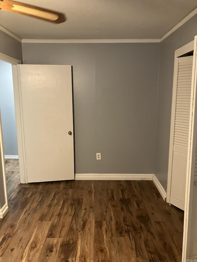 5006 Manor Ave, Little Rock, AR 72204 - unfurnished bedroom featuring crown molding, dark wood-style floors, baseboards, and a closet