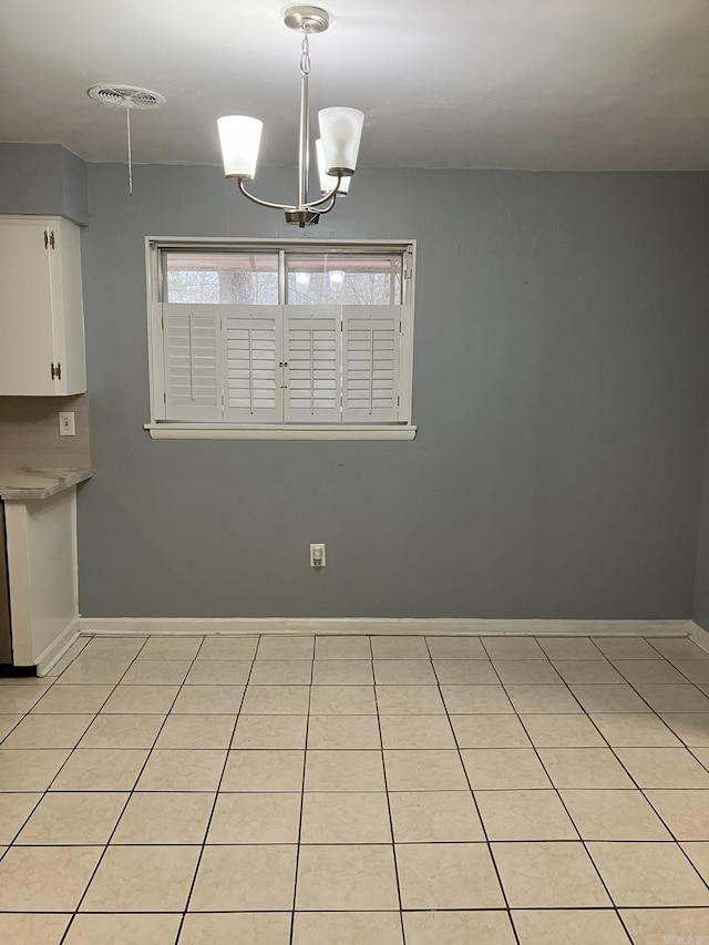5006 Manor Ave, Little Rock, AR 72204 - unfurnished dining area featuring baseboards, light tile patterned floors, and a chandelier