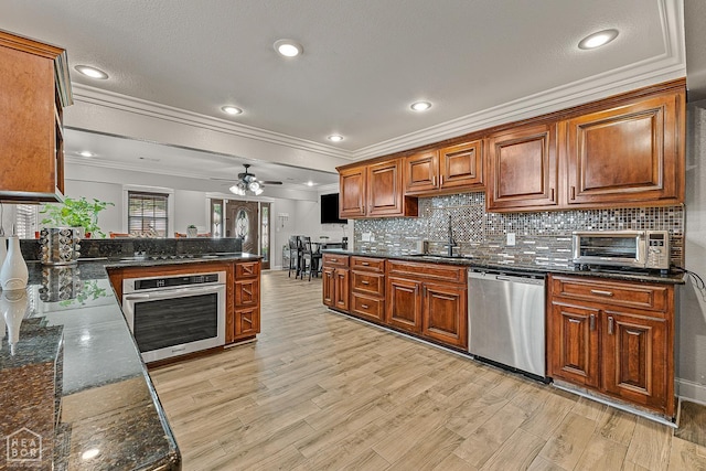3117 Meador Ave, Jonesboro, AR 72401 - kitchen with appliances with stainless steel finishes, crown molding, a sink, light wood-style floors, and decorative backsplash