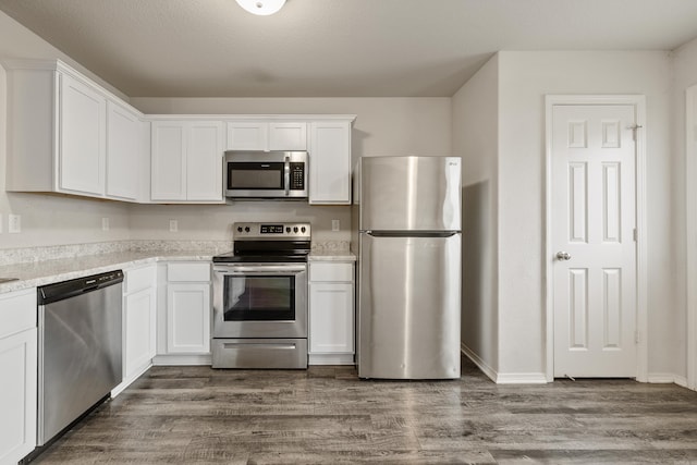 6096 Saddle Hill Dr, Alexander, AR 72002 - kitchen with appliances with stainless steel finishes, white cabinets, dark wood-type flooring, light stone countertops, and baseboards