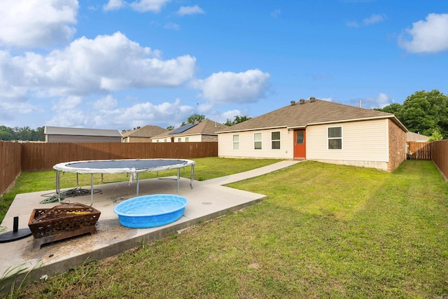 6096 Saddle Hill Dr, Alexander, AR 72002 - back of house with a trampoline, a patio area, and an outdoor fire pit