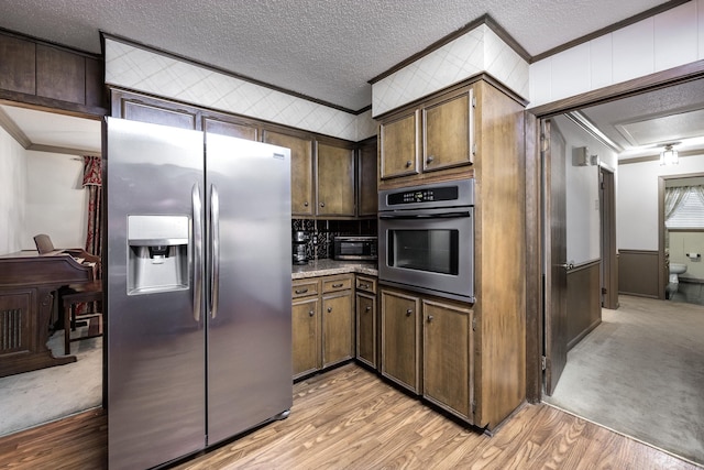 817 Ouachita Pl, Little Rock, AR 72205 - kitchen featuring stainless steel appliances, ornamental molding, light wood-style floors, and a textured ceiling