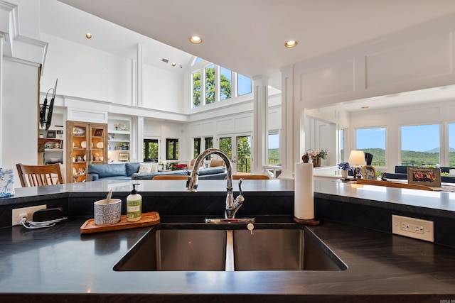 4501 Ridgefield Ln, Little Rock, AR 72223 - kitchen with open floor plan, a sink, dark countertops, a high ceiling, and recessed lighting