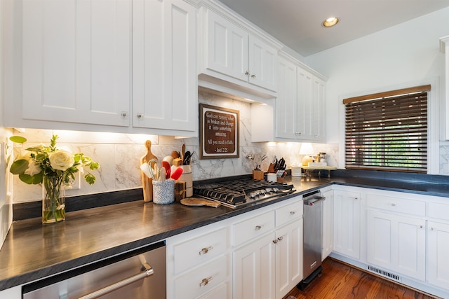 4501 Ridgefield Ln, Little Rock, AR 72223 - kitchen with dark countertops, white cabinets, decorative backsplash, stainless steel appliances, and dark wood-style floors