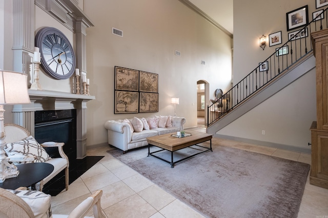 22 Epernay Cir, Little Rock, AR 72223 - living area with a towering ceiling, arched walkways, stairs, light tile patterned floors, and a fireplace