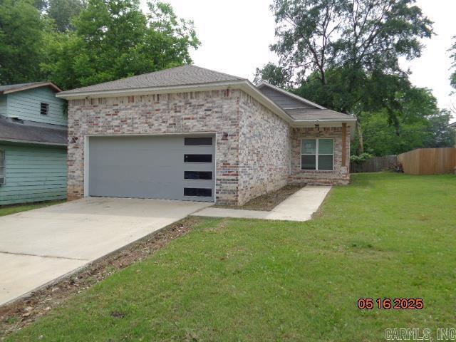 3122 Main St, Little Rock, AR 72206 - view of front of property featuring a garage, brick siding, and driveway