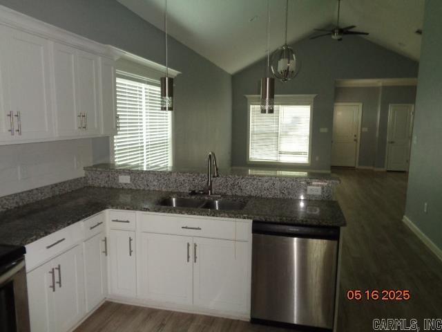 3122 Main St, Little Rock, AR 72206 - kitchen featuring dishwasher, a sink, light wood-type flooring, dark stone countertops, and healthy amount of natural light