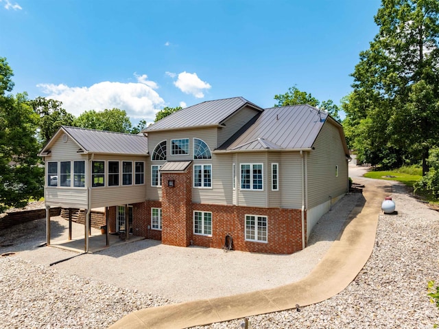 505 E Tri Lks, Horseshoe Bend, AR 72512 - back of house with a sunroom, a patio area, metal roof, a standing seam roof, and gravel driveway