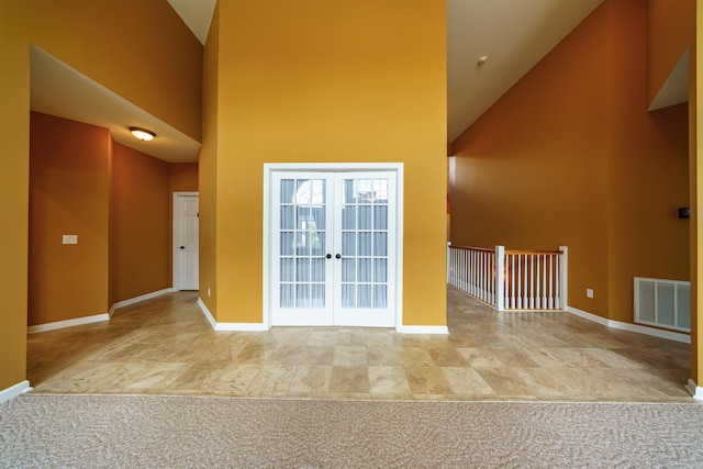 505 E Tri Lks, Horseshoe Bend, AR 72512 - empty room with high vaulted ceiling, baseboards, and french doors