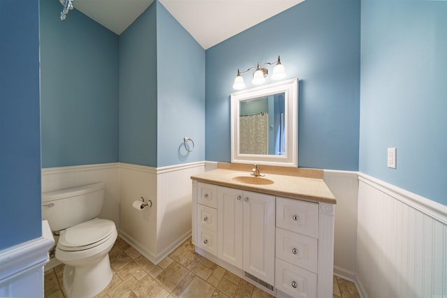 505 E Tri Lks, Horseshoe Bend, AR 72512 - bathroom with wainscoting, vanity, toilet, and stone finish floors