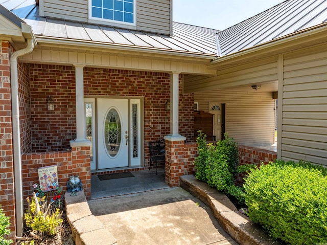 505 E Tri Lks, Horseshoe Bend, AR 72512 - view of exterior entry featuring a standing seam roof, brick siding, metal roof, and a porch