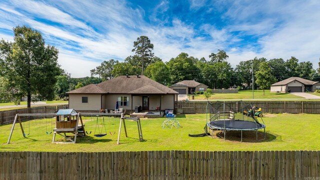 390 Bobwhite Cir, Lonoke, AR 72086 - back of house featuring a trampoline and a playground
