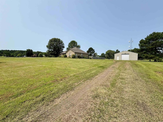 57 Deerfield Dr, Plumerville, AR 72127 - view of green lawn with dirt driveway, a garage, and an outbuilding