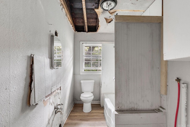 818 W 25th St, North Little Rock, AR 72114 - bathroom with toilet, wood finished floors, and a tub to relax in
