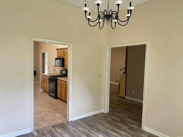 417 Ridge Rd, Pocahontas, AR 72455 - unfurnished dining area featuring a chandelier, baseboards, light wood finished floors, and a high ceiling