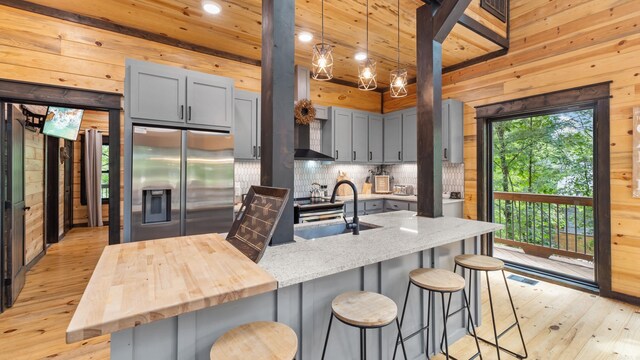 136 Gnarly Maple Trl, Hochatown, OK 74728 - kitchen with stainless steel fridge with ice dispenser, gray cabinets, recessed lighting, light wood-type flooring, and tasteful backsplash