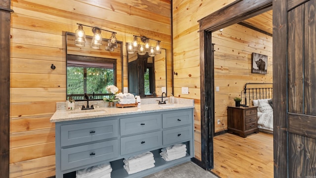 136 Gnarly Maple Trl, Hochatown, OK 74728 - full bathroom featuring wooden walls, double vanity, wood finished floors, and ensuite bath