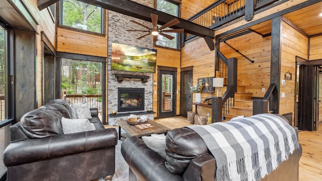 136 Gnarly Maple Trl, Hochatown, OK 74728 - living room with high vaulted ceiling, wood walls, hardwood / wood-style flooring, ceiling fan, and a fireplace