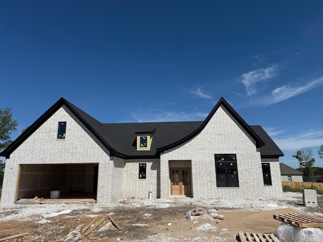 107 Barton St, Beebe, AR 72012 - view of front of house featuring brick siding, a garage, and french doors