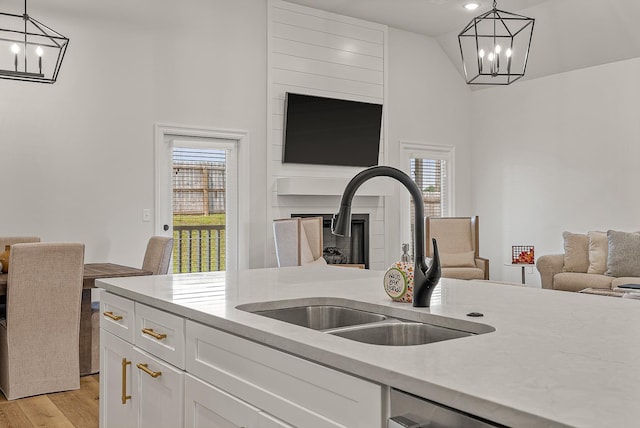 107 Hidden Creek Dr, Brookland, AR 72417 - kitchen featuring a chandelier, a sink, open floor plan, white cabinetry, and high vaulted ceiling