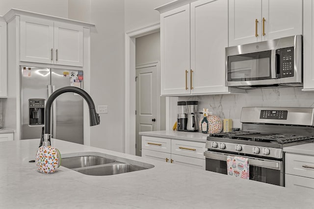 107 Hidden Creek Dr, Brookland, AR 72417 - kitchen featuring appliances with stainless steel finishes, a sink, decorative backsplash, and white cabinetry