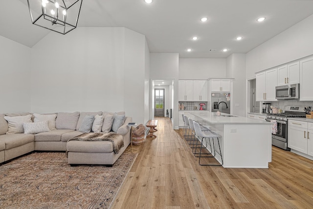 107 Hidden Creek Dr, Brookland, AR 72417 - kitchen featuring appliances with stainless steel finishes, a towering ceiling, a sink, a kitchen breakfast bar, and open floor plan