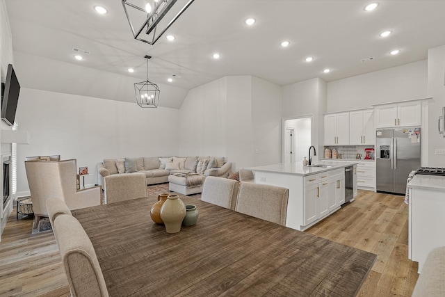 107 Hidden Creek Dr, Brookland, AR 72417 - dining space featuring a chandelier, light wood-type flooring, recessed lighting, a fireplace, and high vaulted ceiling
