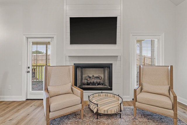 107 Hidden Creek Dr, Brookland, AR 72417 - sitting room with wood finished floors, baseboards, and a large fireplace