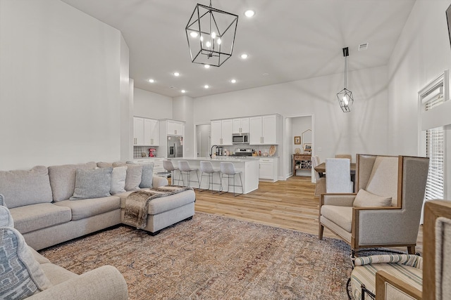 107 Hidden Creek Dr, Brookland, AR 72417 - living area with light wood finished floors, a chandelier, a high ceiling, and recessed lighting