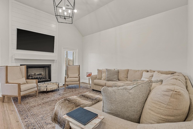 107 Hidden Creek Dr, Brookland, AR 72417 - living area featuring wood finished floors, a chandelier, a fireplace, and high vaulted ceiling