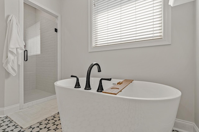 107 Hidden Creek Dr, Brookland, AR 72417 - bathroom featuring plenty of natural light, a shower stall, a freestanding tub, and baseboards