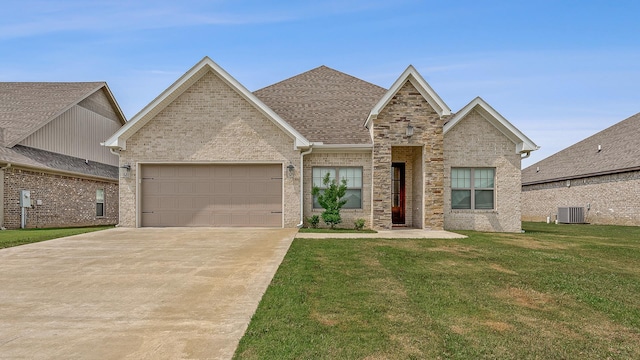 107 Hidden Creek Dr, Brookland, AR 72417 - traditional home featuring an attached garage, a front yard, concrete driveway, central air condition unit, and stone siding