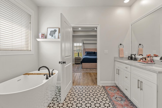 107 Hidden Creek Dr, Brookland, AR 72417 - bathroom featuring double vanity, a freestanding tub, ensuite bath, recessed lighting, and baseboards