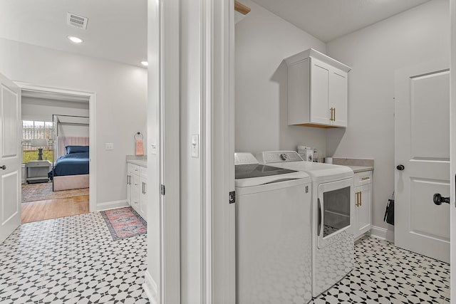 107 Hidden Creek Dr, Brookland, AR 72417 - laundry area featuring light flooring, washer and clothes dryer, cabinet space, and baseboards