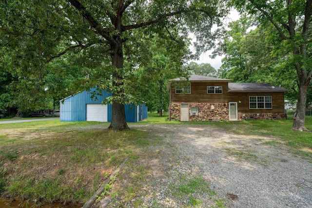 304 Main St, Letona, AR 72143 - split level home with an outbuilding, driveway, a detached garage, stone siding, and a front yard