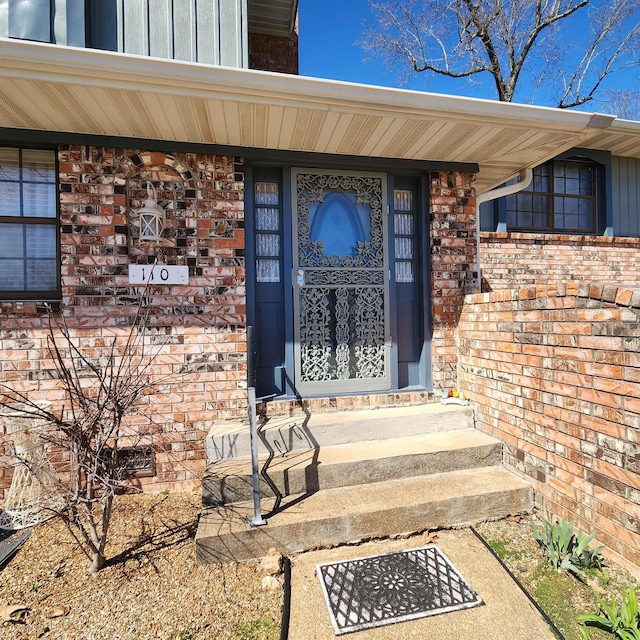 110 Emerald Ln, Horseshoe Bend, AR 72512 - view of exterior entry with board and batten siding and brick siding