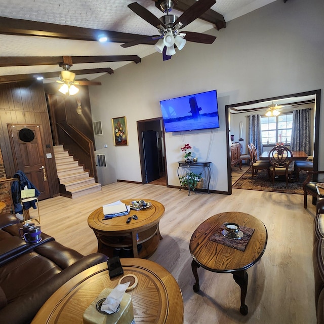 110 Emerald Ln, Horseshoe Bend, AR 72512 - living room with ceiling fan, stairs, wood finished floors, beam ceiling, and a towering ceiling