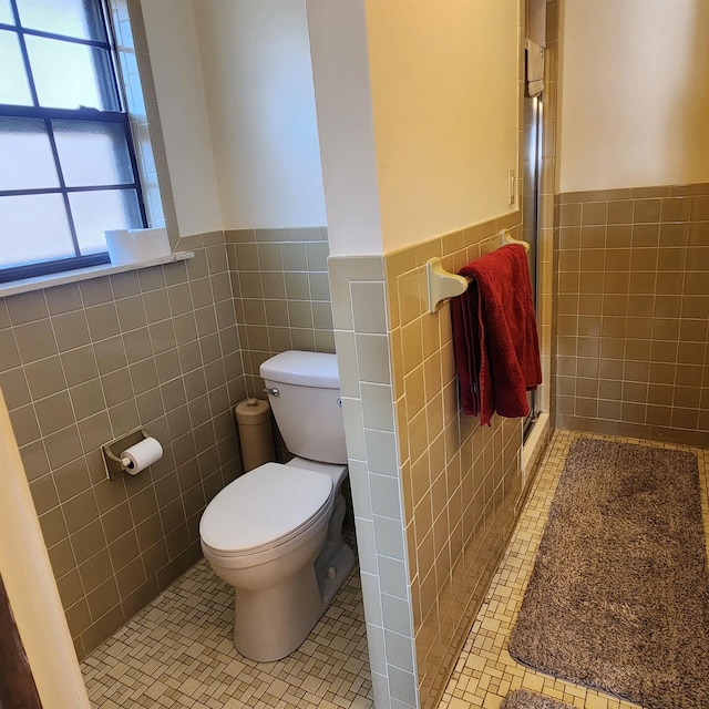 110 Emerald Ln, Horseshoe Bend, AR 72512 - bathroom featuring tile walls, toilet, a wainscoted wall, a shower stall, and tile patterned flooring