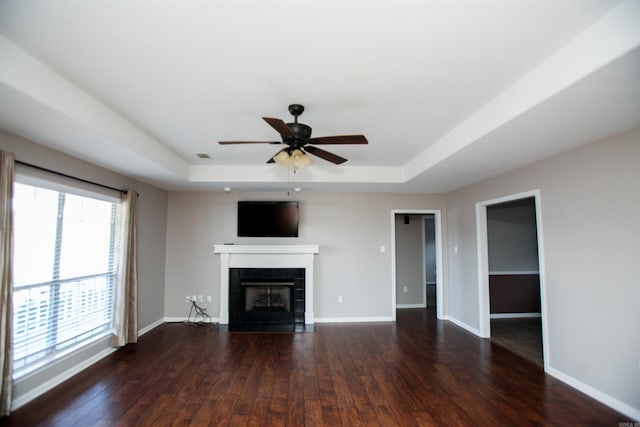 2118 Cedar Rdg, Benton, AR 72015 - unfurnished living room featuring a raised ceiling, a fireplace, dark wood-type flooring, and a ceiling fan