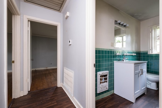 220 N Monroe St, Little Rock, AR 72205 - bathroom with heating unit, tile walls, toilet, vanity, and wood finished floors