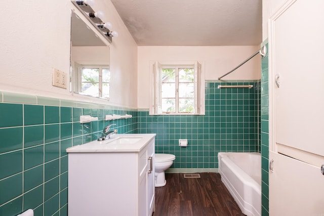 220 N Monroe St, Little Rock, AR 72205 - bathroom featuring tile walls, vanity, toilet, wainscoting, and wood finished floors